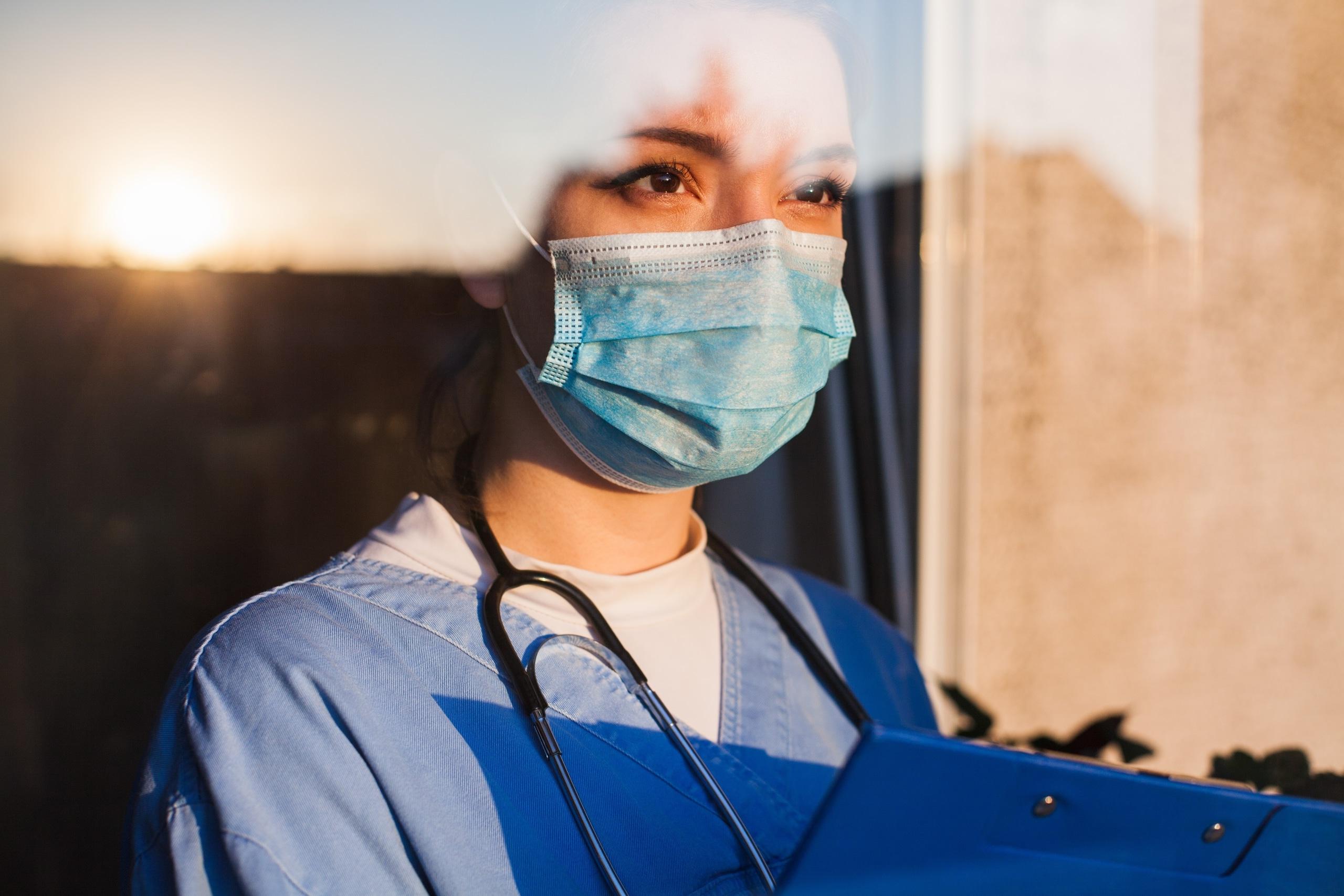 Young nurse looking through a window